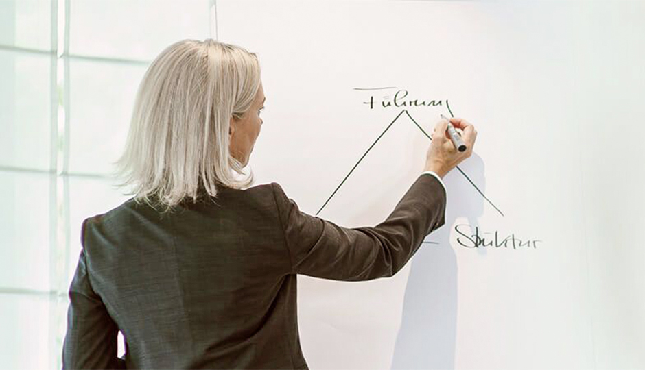 Eine Frau schreibt auf ein Flipchart
